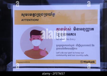 A bilingual COVID - 19 warning sign 'No Face Mask, No Entry' at the entrance to a bank during the coronavirus pandemic. Steung Meanchey, Phnom Penh, Cambodia. © Kraig Lieb Stock Photo