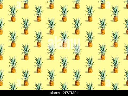 Seamless pattern of many ripe pineapples isolated on yellow background. Tropical fruit Stock Photo