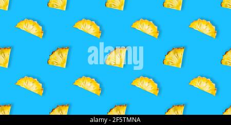 Seamless pattern of fresh ripe pineapple slices isolated on blue background. Top view. Exotic tropical fruit Stock Photo
