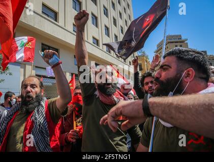 Beirut, Lebanon. 28th Mar, 2021. Members of the Lebanese Communist Party chant slogans during a protest near the headquarters of the Prime Minister of Lebanon. The protesters call for the formation of a national coalition against the ruling regime amid an acute economic situation and political impasse. Credit: Marwan Naamani/dpa/Alamy Live News