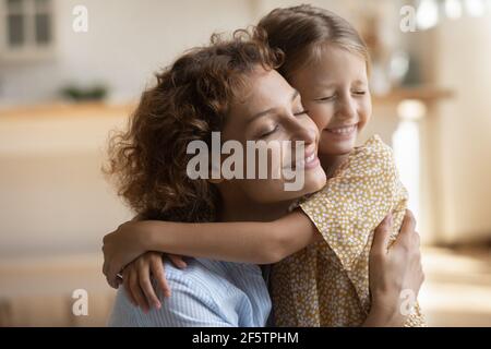 Small girl child hug mom showing love Stock Photo