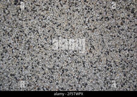 Rough textured wall made from black and white pebbles, abstract background, wall pattern, grunge rock backdrop Stock Photo