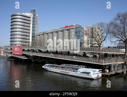 AMSTERDAM,NETHERLANDS-MARCH 9:Tour Boat, Bicycle Parking Garage and Ibis Hotel .March 9,2014 in Amsterdam, Netherlands. Stock Photo