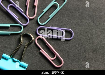 Multicolored paper clips on a dark background Stock Photo
