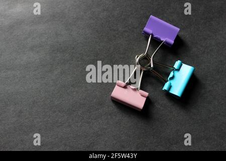Multicolored paper clips on a dark background Stock Photo