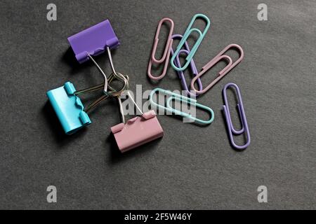 Multicolored paper clips on a dark background Stock Photo