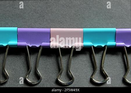 Multicolored paper clips on a dark background Stock Photo