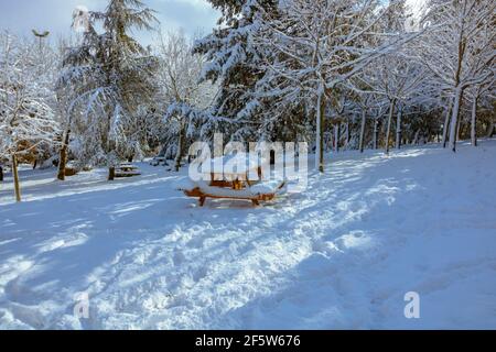Snow covered picnic table in the park at winter. Snowy park. Winter background photo. Stock Photo