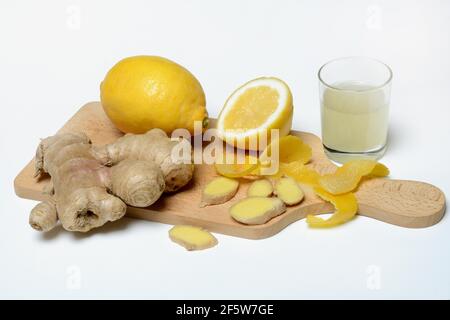 Ginger root and lemon on wooden board and glass of ginger lemon juice, Germany Stock Photo