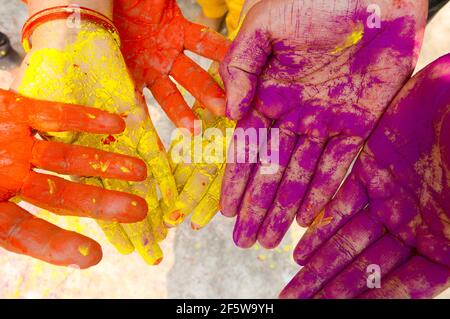 Young people with colorful powder in hands at holi festival in India celebrated with different colors. Holi hands, colorful hands illustration. Close Stock Photo