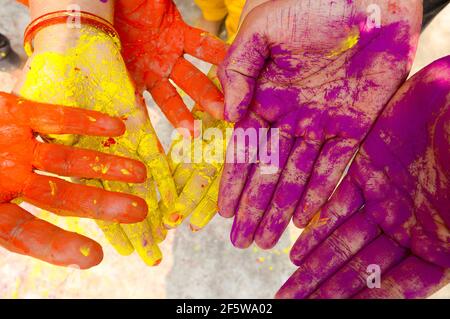 Young people with colorful powder in hands at holi festival in India celebrated with different colors. Holi hands, colorful hands illustration. Close Stock Photo