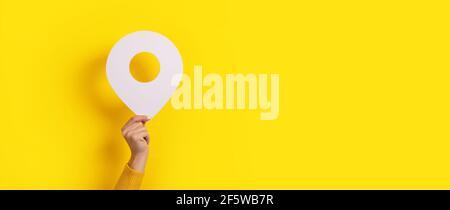 map pointer 3d pin in hand over yellow background Stock Photo