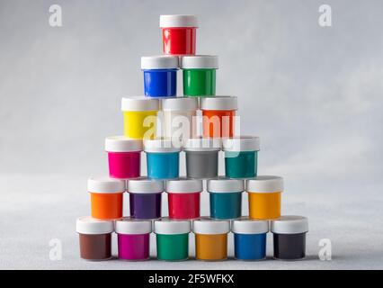 Pyramid of colorful gouache cans on gray background Stock Photo