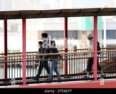 Hong Kong, China. 28th Mar, 2021. Pedestrians wearing face masks are seen in Hong Kong, south China, March 28, 2021. Hong Kong reported zero local infection of COVID-19 for the second straight day on Sunday. The Center for Health Protection said in a statement that only one imported case was found during the past 24 hours ending the midnight of Saturday, dropping further from six imported cases the previous day. The COVID-19 tally in Hong Kong stood at 11,446 on Sunday. Credit: Li Gang/Xinhua/Alamy Live News Stock Photo