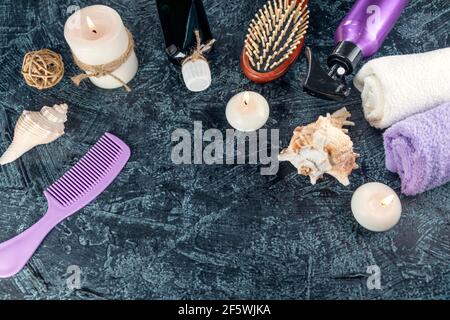 Spa resort therapy composition. Bath bomb, burning candles, towel, massage oil, soap, washcloths, combs Top view Soft focus Stock Photo