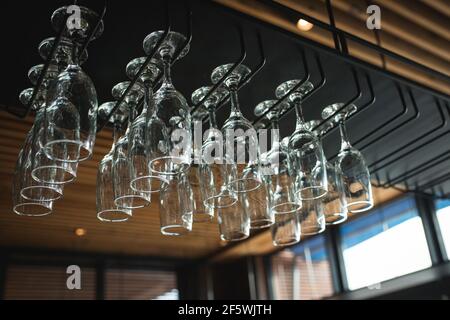 A row of empty glasses hang over the bar counter Stock Photo
