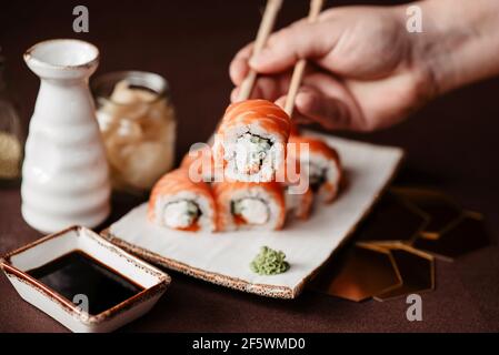 Sushi set with salmon and avocado on a clay plate