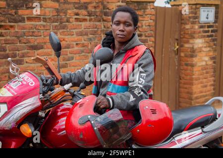 Kigali, Rwanda. 23rd Mar, 2021. Female moto-taxi rider Claudine Nyirangirente poses for a photo in Kigali, Rwanda, March 23, 2021. TO GO WITH 'Feature: Rwanda's female motorcycle rider defies odds to join male-dominated job' Credit: Cyril Ndegeya/Xinhua/Alamy Live News Stock Photo