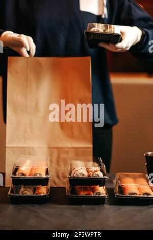 delivery woman in gloves packing food and drinks Stock Photo - Alamy