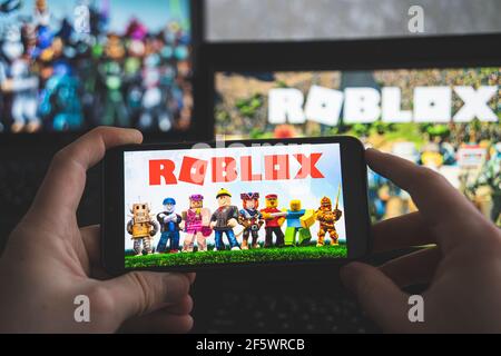 Roblox is an online game platform and game creation system. A smartphone  with the Roblox logo on the screen on the pile of the gamepads Stock Photo  - Alamy