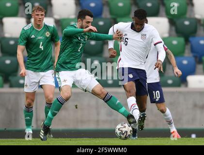 Northern Ireland's Conor McLaughlin (left) and USA's Theoson Siebatcheu battle for the ball during the international friendly at Windsor Park, Belfast. Picture date: Sunday March 28, 2021. Stock Photo