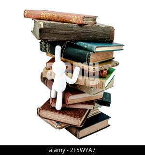 White statue climbing on old English vintage books backstage white background Stock Photo