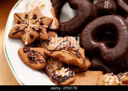 Simple fresh decorated homemade tasty holiday gingerbread cookies and chocolate cookies laid out on a plate, set detail, closeup. Home made pastries, Stock Photo