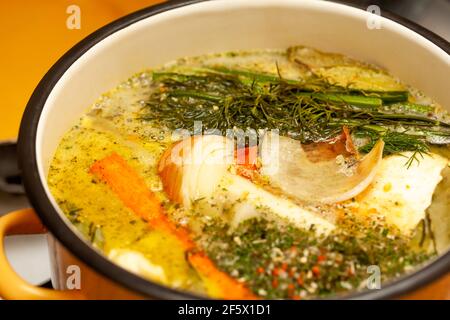 Broth, traditional polish rosół, tasty home made rosol chicken soup cooking in a large pot, surface closeup, detail, dish preparation. Fresh vegetable Stock Photo