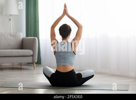 Rear view of young woman practicing yoga tree pose on beach, Dominican ...