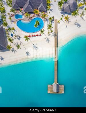 Aerial view of Maldives island, luxury water villas resort and wooden pier. Beautiful sky and ocean lagoon beach background. Summer vacation holiday Stock Photo