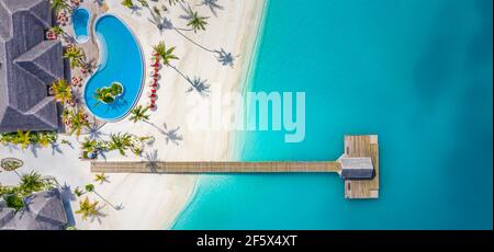 Aerial view of Maldives island, luxury water villas resort and wooden pier. Beautiful sky and ocean lagoon beach background. Summer vacation holiday Stock Photo