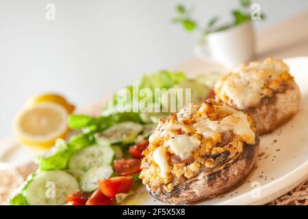 Mediterranean food. Stuffed mushrooms whith cheese, salad, tomato, cucumber, lemon. Stock Photo