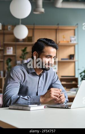 Bearded indian businessman working studying on laptop computer in office. Stock Photo