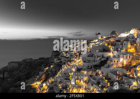 Selective color image, orange color with black and white process. Night lights over Oia village Santorini, Greece. Famous travel destination, artistic Stock Photo
