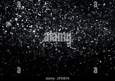 Many snowflakes in blur on black background. Snowfall layer for winter photo. Stock Photo