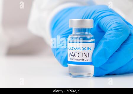 Covaxin vaccine against SARS-Cov-2, coronavirus or Covid-19 put on the table by medical worker in the rubber gloves.  Stock Photo