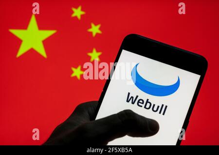 China. 28th Mar, 2021. In this photo illustration the financial services company Webull logo seen on an Android mobile device with People's Republic of China flag in the background. (Photo by Budrul Chukrut/SOPA Images/Sipa USA) Credit: Sipa USA/Alamy Live News Stock Photo