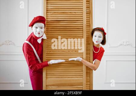 Two mime artists, scene with wooden partition Stock Photo