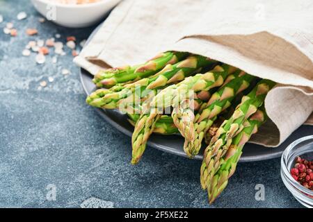 Asparagus. Fresh green asparagus bunch ready for cooking on gray slate stone table background. Top view copy space. Stock Photo