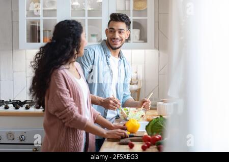 Happy Arab Spouses Preparing Healthy Lunch Together In Kitchen Stock Photo
