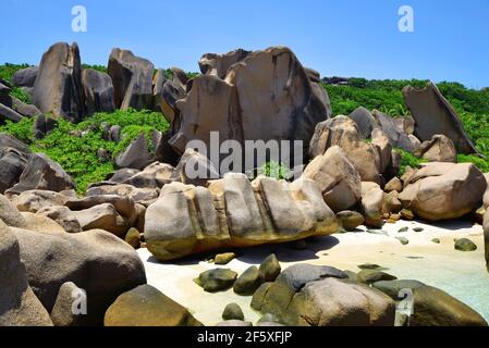 Anse Marron beach with big granite boulders on La Digue Island, Seychelles. Tropical landscape with sunny sky. Exotic travel destination. Stock Photo
