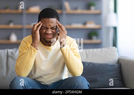 Upset african american young man having headache Stock Photo