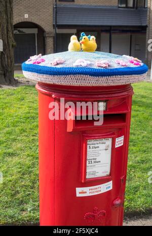 Easter themed knitted cosy on top of a postbox in Whickham, North East England UK Stock Photo