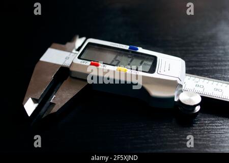 Electronic vernier caliper on a wooden table close up Stock Photo