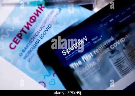 View of the Russian certificate of vaccination against novel coronavirus infection COVID-19 and the website of the Russian vaccine Sputnik V on tablet Stock Photo