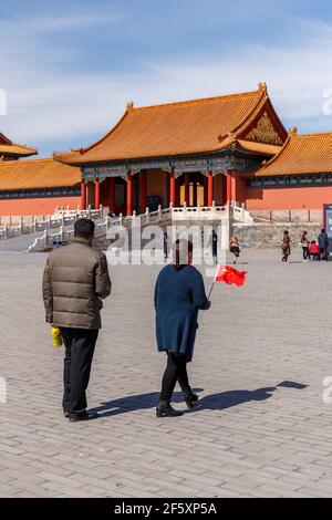 Couple with a small Chinese flag at the Forbidden City in Beijing, China in March 2018. Stock Photo