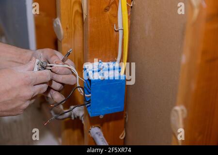 Preparing to remove an electrical outlet of the screws for electrical wires receptacle plug panel Stock Photo