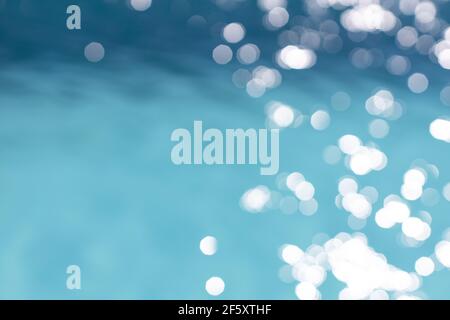 View of blurry surface of turquoise water with glare in swimming pool, sea, lake, or ocean, summer mood background. Concept rest, travel, wellness, sp Stock Photo