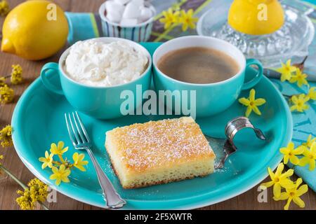 piece of lemon cake on the plate, cup of coffee and whipped cream Stock Photo