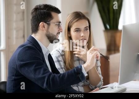 Serious diverse employees work on computer in office Stock Photo
